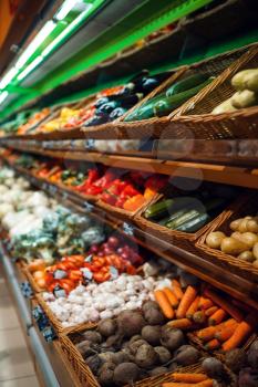 Showcase with fresh fruits and vegetables in grocery store, nobody. Organic food choice in market, supermarket assortment on shelf