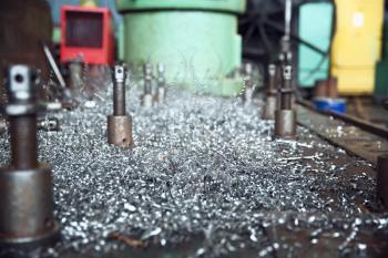 Metal shavings on lathe closeup, metalworking factory, nobody. Metal manufcturing, metalwork turning on plant. Turner workplace, tools and equipment for steel processing