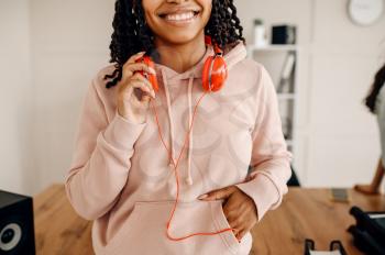 Smiling female person with headphones, music relaxation. Pretty lady in earphones relax in the room, sound lover resting