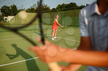 Man and woman with rackets, tennis training on outdoor court. Active healthy lifestyle, people play sport game, fitness workout with racquets