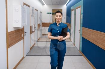 Smiling female doctor poses in clinic. Doctor in uniform, medical worker, medicine and health, professional healthcare in hospital