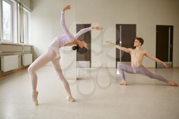 Couple of ballet dancers, dancing repetition. Ballerina with partner training in class, dance studio interior on background