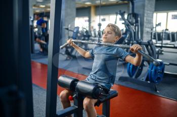 Boy on exercise machine, training in gym. Youngster in sport club, healthcare and healthy lifestyle, schoolboy on workout, sportive youth