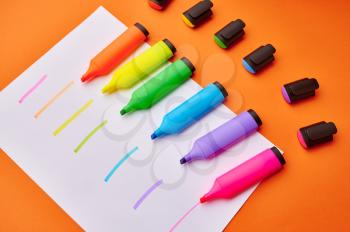 Set of opened colorful permanent markers on paper sheet with strokes. Office stationery supplies, school or education accessories, writing and drawing tools
