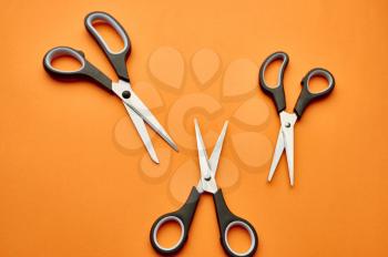 Set of scissors closeup, orange background. Office stationery supplies, school or education accessories, writing and drawing tools
