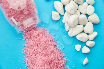 Pink sea salt on blue background, nobody. Healthcare procedures concept, mineral hygiene products, spa therapy, skin care