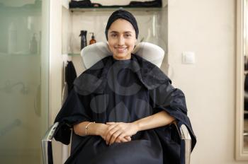 Smiling female customer in hairdressing salon. Happy woman in hairsalon. Beauty business, professional service, hair care