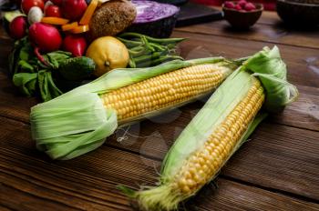 Fresh corncob on wooden background, corn cobs. Organic vegetarian food, grocery assortment, natural products, healthy lifestyle concept,