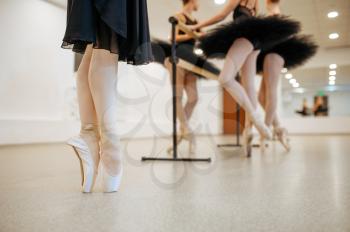 Three young ballerinas, teens rehearsal at the barre in class. Ballet school, female dancers on choreography lesson, girls practicing dance