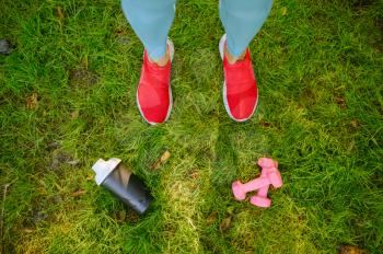 Woman on morning fit training in park, top view on feets. Female runner goes in for sports at sunny day, healthy lifestyle, jogger on outdoors workout