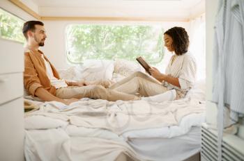 Love couple relax in bedroom, camping in a trailer. Man and woman travels on van, romantic vacations on motorhome, campers leisures in camping-car