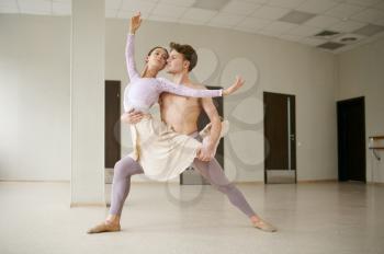 Couple of ballet dancers, performance in action. Ballerina with partner training in class, dance studio