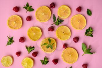 Fresh lemon slices and strawberries on pink background. Organic vegetarian food, grocery assortment, natural eco products, healthy lifestyle concept