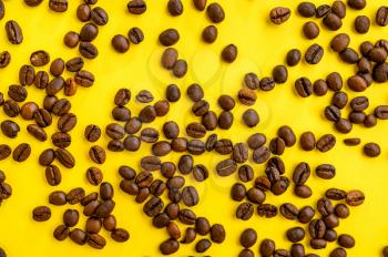 Coffee beans closeup isolated on yellow background, top view. Organic vegetarian food, grocery assortment, natural eco products, healthy lifestyle concept