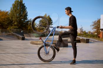 Male bmx biker doing trick, training in skatepark. Extreme bicycle sport, dangerous cycle exercise, risk street riding