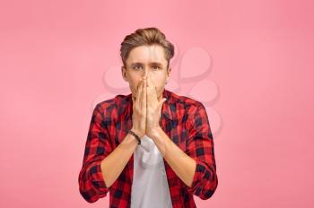 Sad man portrait, pink background, emotion. Face expression, male person looking on camera in studio, emotional concept, feelings