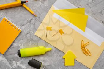 Office stationery supplies in yellow tones, marble background. School or education accessories, writing and drawing tools, pencils and rubbers, ruler and paper clips