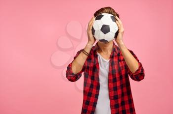 Portrait of serious man with football ball, pink background, emotion. Face expression, male person looking on camera in studio, genre concept, feelings
