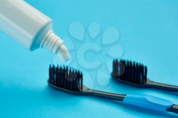 Oral care products, blue background, nobody. Morning healthcare procedures concept, toothcare, toothbrush and toothpaste