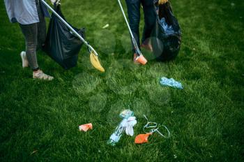 Two men collects plastic garbage in bags in park, volunteering. Male person cleans forest, ecological restoration, eco lifestyle, trash collection and recycling, ecology care, cleaning