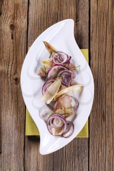 Pan fried meat with onion and endive leaves