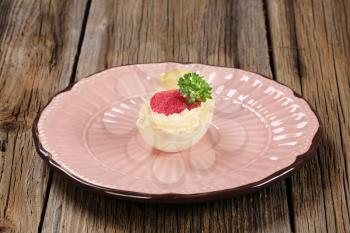 Egg white stuffed with savory spread and red caviar
