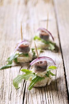 Anchovy canapes garnished with greens and onion