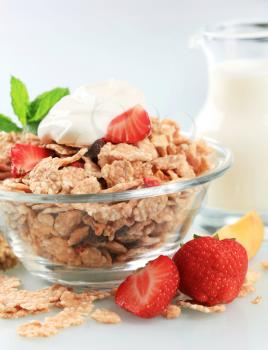 Bowl of crispy flakes with fresh strawberries and yogurt