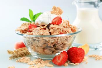 Bowl of crispy flakes with fresh strawberries and yogurt
