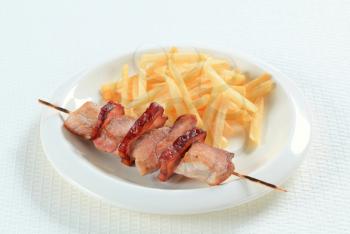 Pork skewer served with French fries 