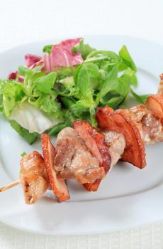 Pork skewer with mixed salad greens 