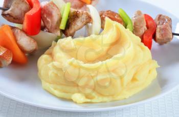 Pork skewers served with mashed potato 