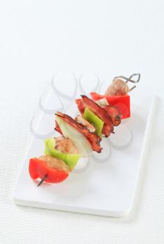 Meat and vegetable skewer on cutting board