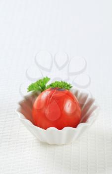 Lightly grilled tomato in a small porcelain dish