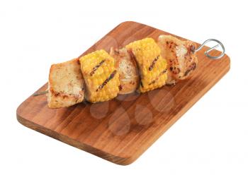 Turkey and sweet corn skewer on cutting board
