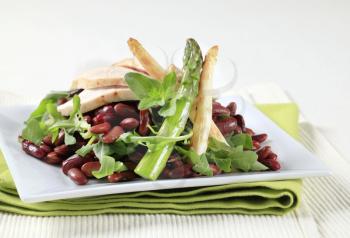 Slices of chicken breast with red beans and arugula