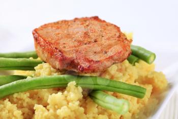 Dish of marinated pork with couscous and green beans