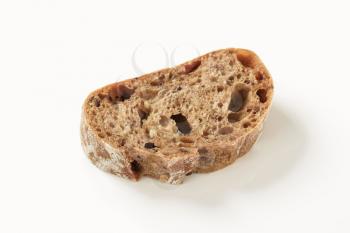 Slice of brown bread on white background
