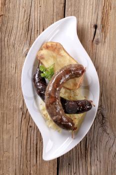 Blood sausage and white pudding with sauerkraut and baked potato