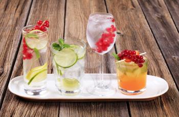 Glasses of iced drinks garnished with fresh fruit