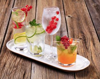 Glasses of iced drinks garnished with fresh fruit