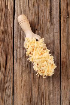 Grated cheese on a wooden scoop - overhead