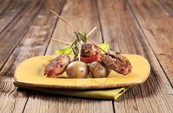 Minced meat kebabs on sticks and new potatoes