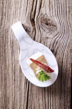 Cheese hors d'oeuvre on a porcelain spoon