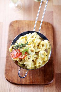 Cooked tortellini in a metal sieve - overhead
