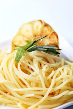 Cooked spaghetti and baked garlic - detail