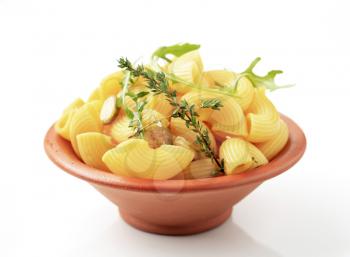 Bowl of macaroni with sliced capers and rocket