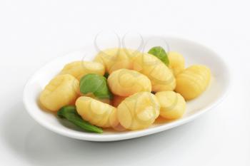Plate of boiled Italian dumplings and fresh basil