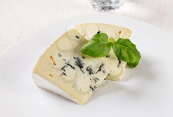 Wedges of blue cheese with white rind