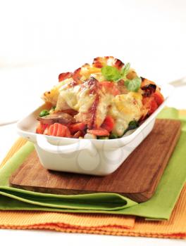 Fish and vegetable casserole topped with cheese